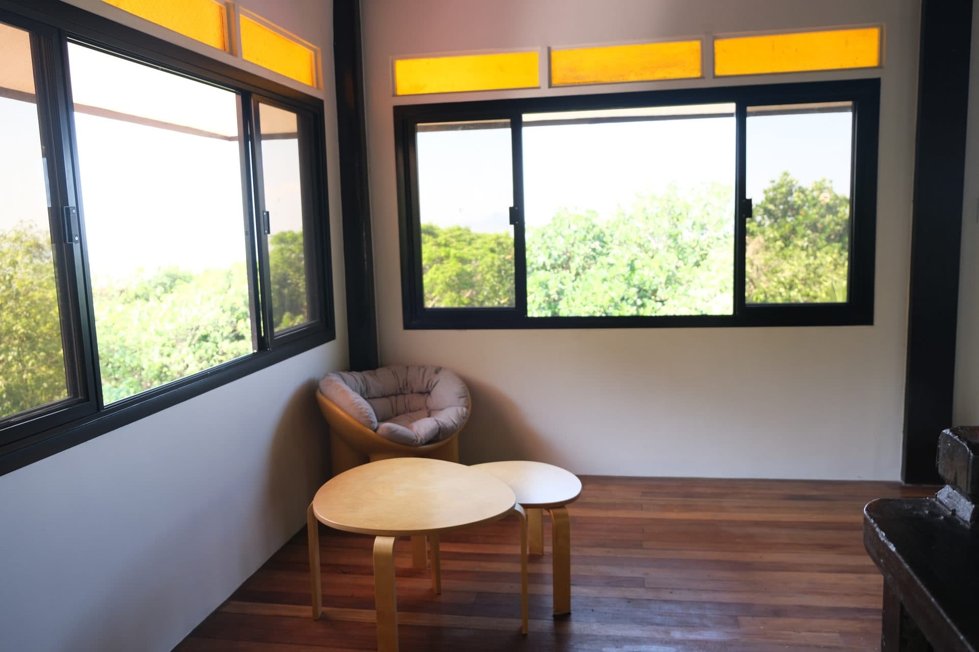 Upstairs lounge seating area with treetop views